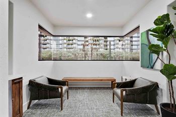 a living room with two chairs and a table and a window